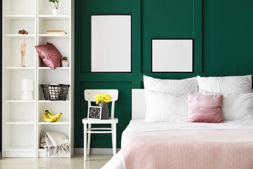 Stylish interior of bedroom with comfy bed, shelves and blank posters