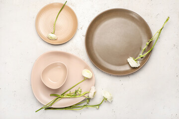 Simple table setting and ranunculus flowers on light background