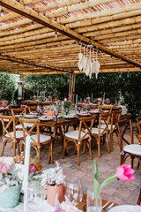 Terrace with tables setup with flowers and plates on table decorated for Wedding Reception in Latin America