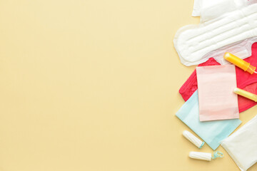 Menstrual pads, tampons and panties on yellow background