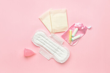 Menstrual cup, pads and tampons on pink background - obrazy, fototapety, plakaty
