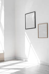 Blank frames hanging on light wall in room