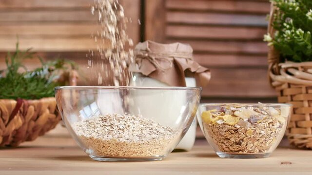 Sprinkling muesli granola with dry fruit and raisin transparent glass bowl for healthy breakfast