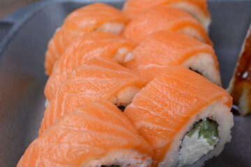 Rolls with salmon fish, close-up on a dark gray background