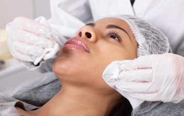 Procedure for manual cleansing of the facial skin from blackheads and acne. Beauty parlour.