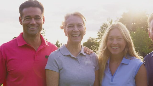Camera tracks along faces of mature and mid adult couples playing round of golf and smiling into camera - shot in slow motion