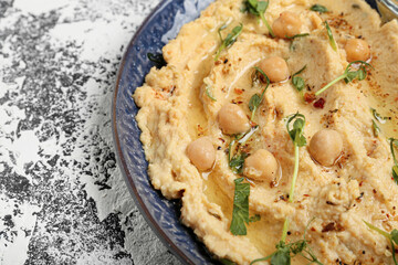 Plate with delicious hummus on color background, closeup