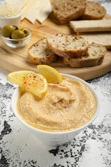 Bowl with delicious hummus on color background, closeup