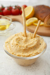 Bowl with delicious hummus and crackers on light background, closeup