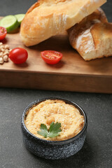 Bowl with delicious hummus on dark background