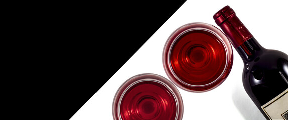 Two glasses and a bottle of red wine on a white background.Place for text material.