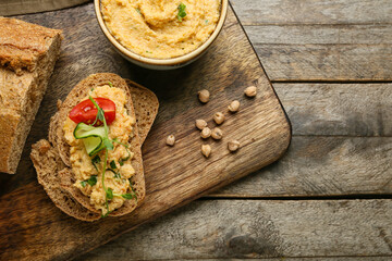 Sandwich with delicious hummus on wooden background