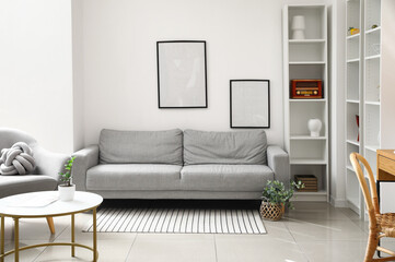 Interior of modern room with sofa, table and shelf unit