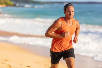 Running athlete man on beach sweating training cardio on intense hiit workout in summer...