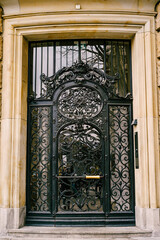 Forged door with glass inserts on the facade of a marble building