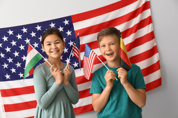Pupils of language school near light wall with USA flag