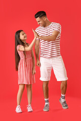 Man and his little daughter giving each other high-five on color background