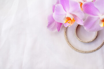 Bracelet and necklace on white fabric and purple Orchid
