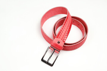 Rolled up red belt with metal buckle. Fashionable accessory.