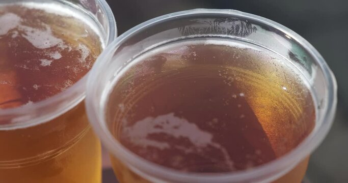 two plastic cups with cold beer close-up