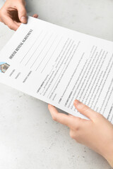 Women with house rental agreement on light background, closeup