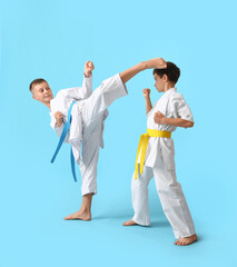 Little boys practicing karate on color background © Pixel-Shot