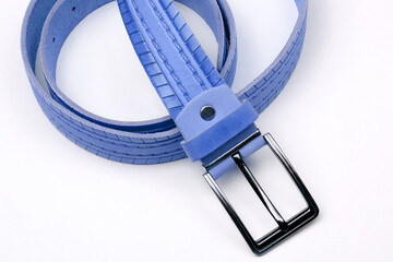 Rolled up blue belt with metal buckle. Fashionable accessory.