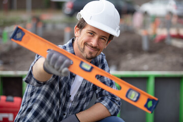 builder holding spirit level at construction site