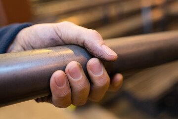 Fototapeta na wymiar closup of male hand gripping metal tube in industrial factory