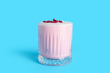 Glass of tasty rose latte on color background