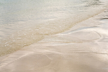 transparent water ripple and sunlight glare on white sand background