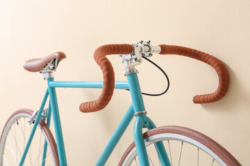 Modern bicycle near beige wall, closeup