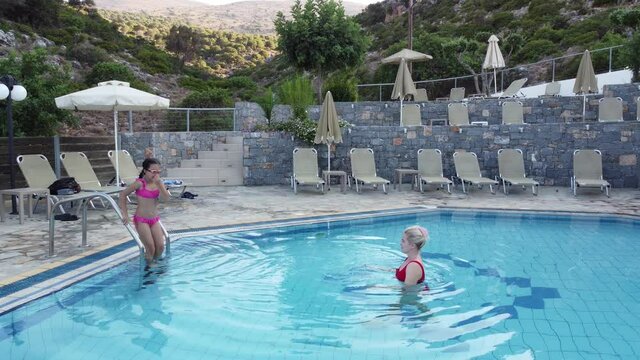 Beautiful woman with her daughter in swimming pool