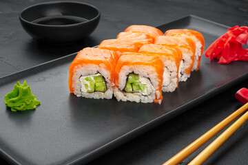 Fresh philadelphia sushi roll served on black plate