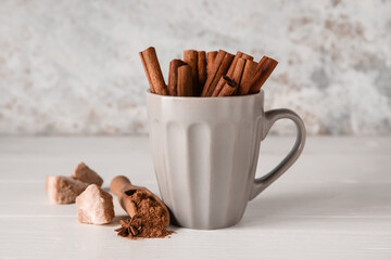 Cup with natural cinnamon sticks on table
