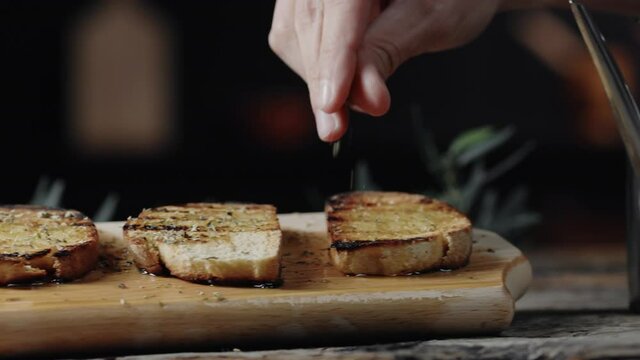 Bruschette di pane con olio e origano su tagliere di legno
