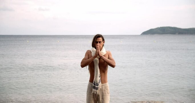 Caucasian spiritual man meditating on beach 