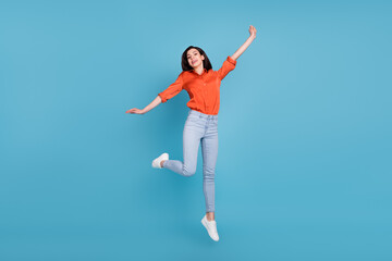 Full length body size view of attractive cheerful girl jumping resting having fun isolated over bright blue color background