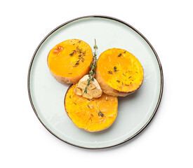Plate with baked pumpkin pieces on white background
