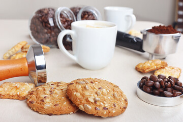 Breakfast with sweets, cup of coffee, coffee beans and ground coffee on table.
