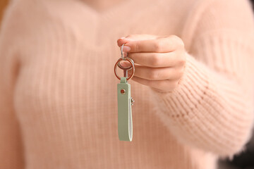 Woman holding key on chain, closeup