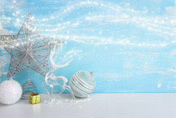 Image of christmas decorations and crystal deer in front of pastel blue background