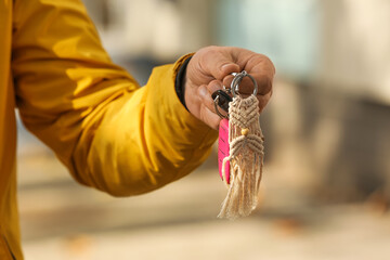 Man holding keys on chain outdoors
