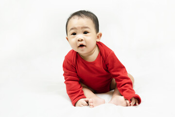 Naklejka premium Cute infant baby boy toddler in red bodysuit.Concept holiday Christmas, happy new year, infants, childhood.