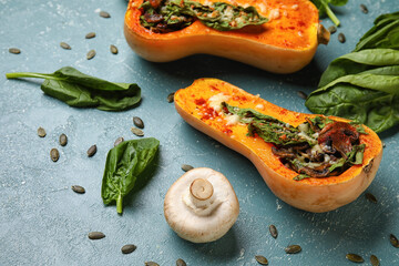 Tasty stuffed pumpkins and ingredients on green background