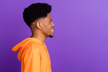 Obraz premium Profile side photo of happy afro american man look empty space smile face isolated on purple color background