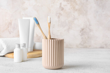 Holder with toothbrushes and bath supplies on light table