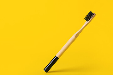 Wooden toothbrush on yellow background