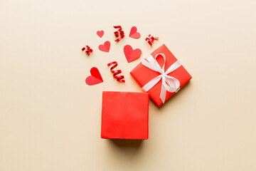 Happy valentines day opened heart shape gift box with small hearts, on colored background, valentines day card - top view concept