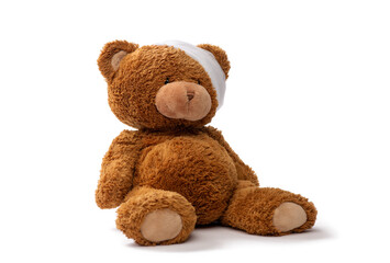 medicine, healthcare and childhood concept - teddy bear toy with bandaged head on white background